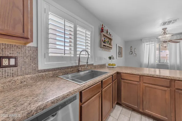an empty room with wooden floor ceiling fan and windows
