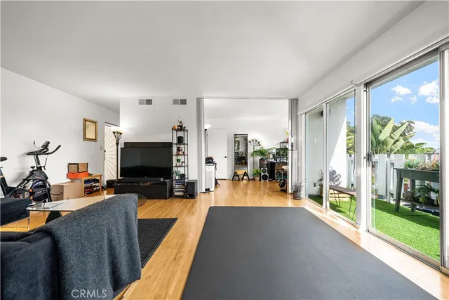 a living room with furniture a flat screen tv and a floor to ceiling window