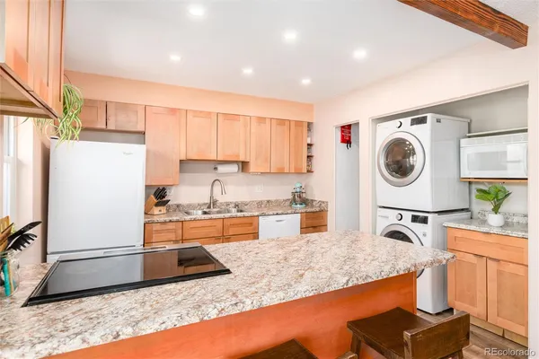 a kitchen with stainless steel appliances granite countertop a sink a stove and a refrigerator