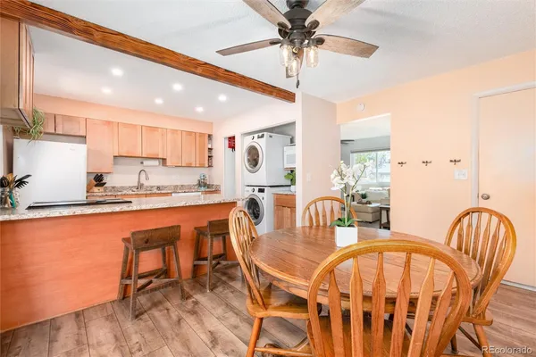 a dining room with stainless steel appliances a table and chairs