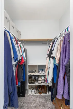 a view of walk in closet with clothes and shoes