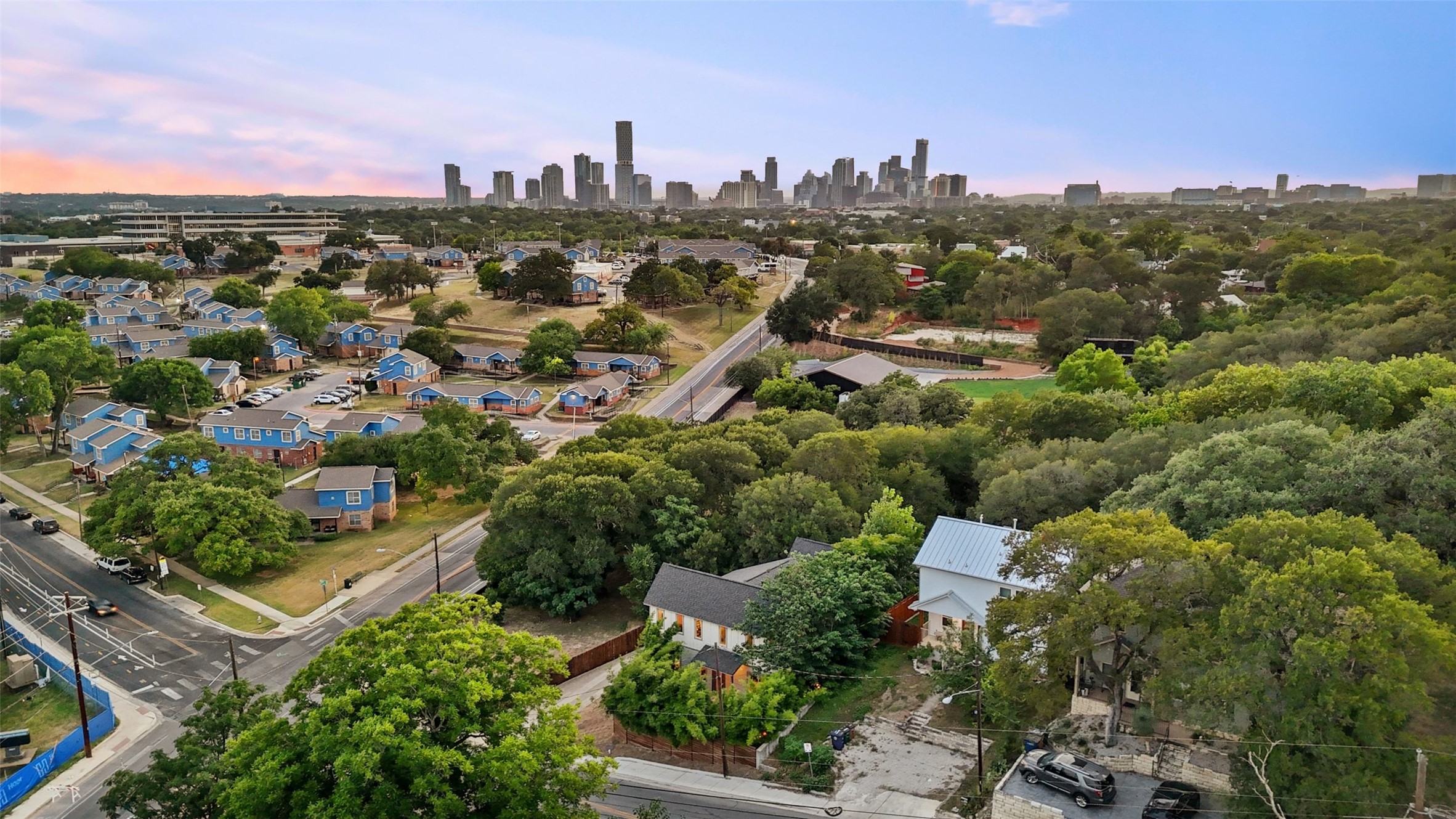 1158 Ridgeway Drive, Unit A Austin, TX 78702 - Photo 25 of 28 An aerial perspective reveals a vibrant neighborhood nestled among lush trees, with the distant city skyline creating an impressive backdrop.