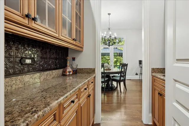 a kitchen with stainless steel appliances granite countertop a stove a sink dishwasher and a refrigerator with wooden floor