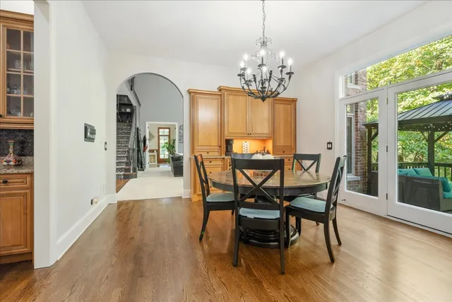 a spacious bedroom with a bed a chandelier and a chair
