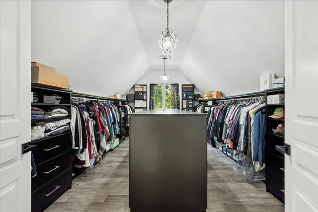 a kitchen with stainless steel appliances kitchen island granite countertop a table chairs sink and cabinets