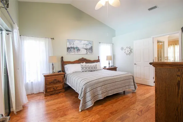 a bedroom with a bed and a flat tv screen on dresser