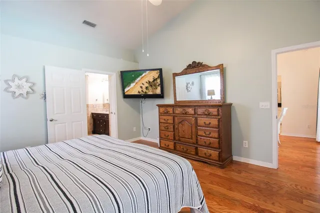a bedroom with a bed and wooden floor