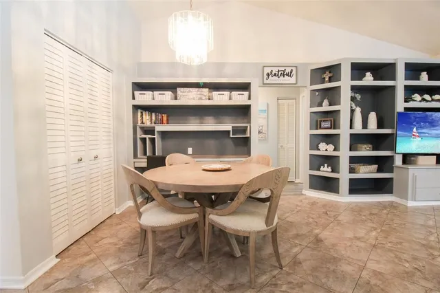 a kitchen with stainless steel appliances kitchen island granite countertop a refrigerator a stove a sink a dining table and chairs with wooden floor