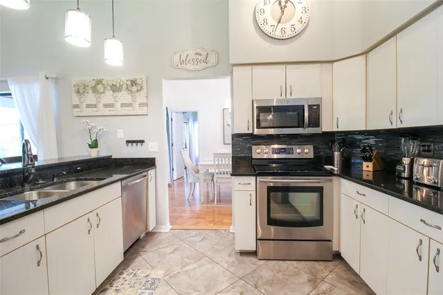a view of a hallway with wooden floor and a living room