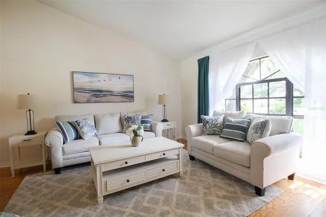 a living room with furniture a chandelier and a dining table