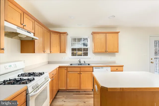 a kitchen with a sink a stove and cabinets
