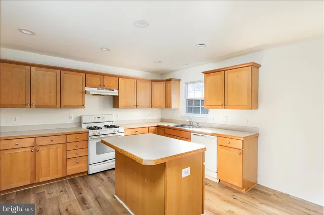 a kitchen with stainless steel appliances a sink stove and cabinets