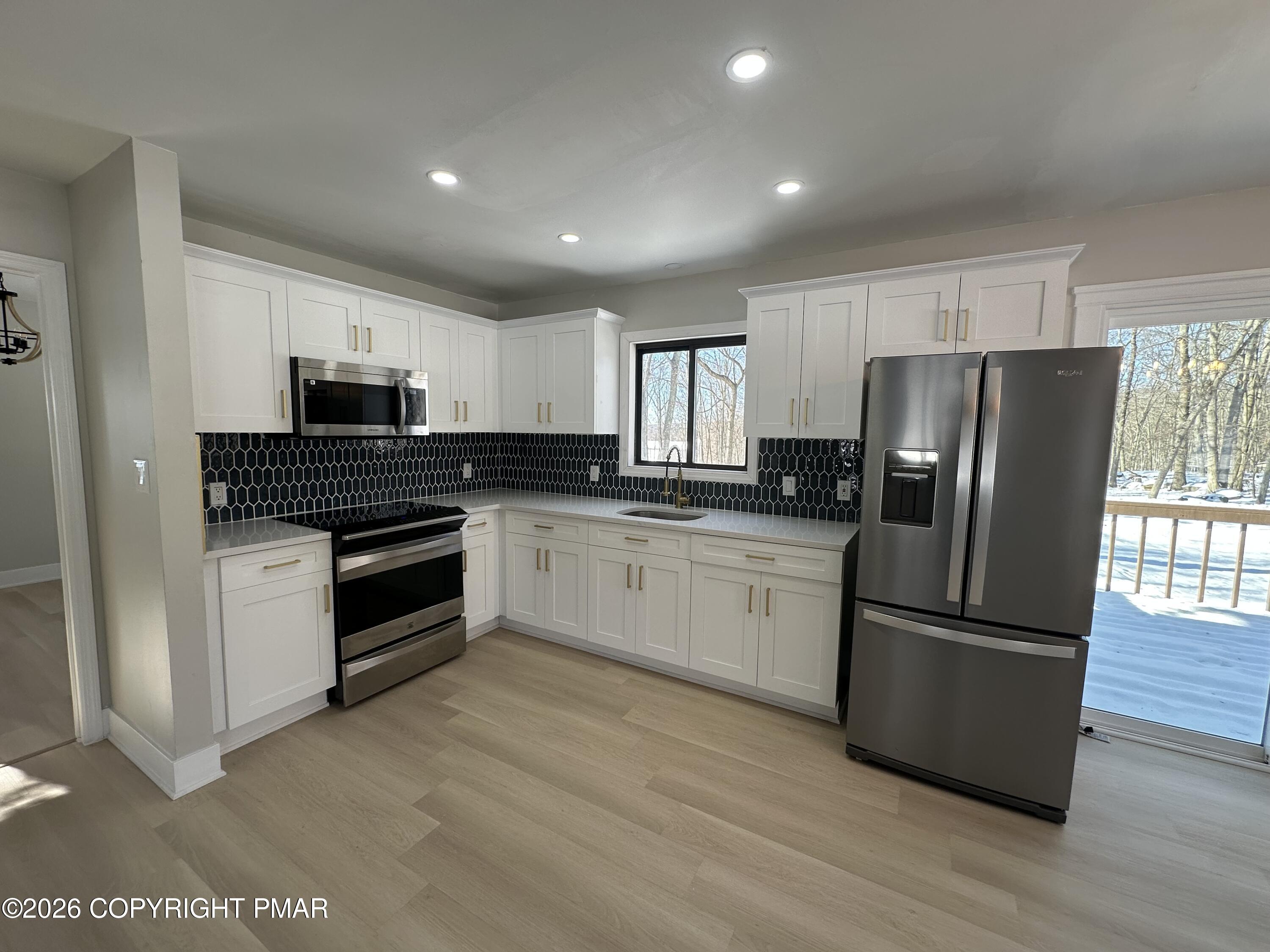 147 Pocono Boulevard Bushkill, PA 18324 - Photo 12 of 28 a kitchen with granite countertop white cabinets and stainless steel appliances