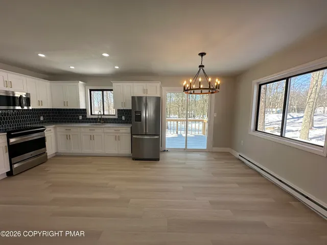 a view of a kitchen with granite countertop stainless steel appliances and a window