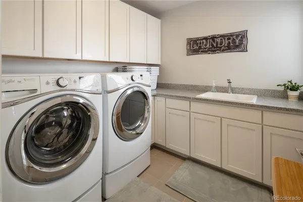 a utility room with sink dryer and washer
