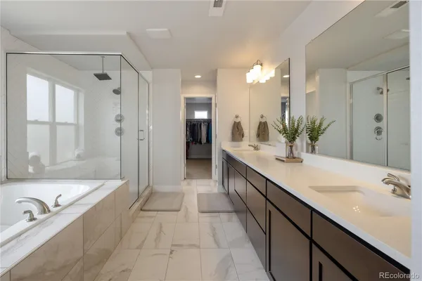 a spacious bathroom with a tub sink shower and mirror