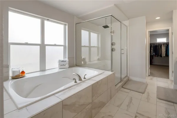 a bathroom with a tub a sink and a window