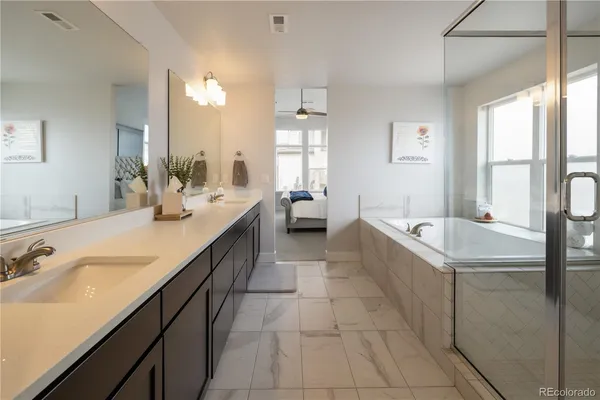 a spacious bathroom with a tub sink and mirror