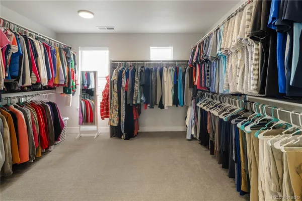 a view of walk in closet with clothes and shoes