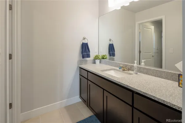 a bathroom with a granite countertop sink and a mirror