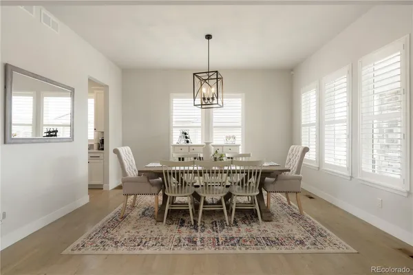 a dining room with wooden floor and window