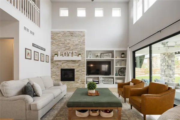 a living room with furniture a flat screen tv and a fireplace
