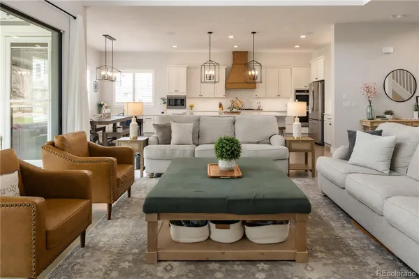 a living room with furniture kitchen view and a large window