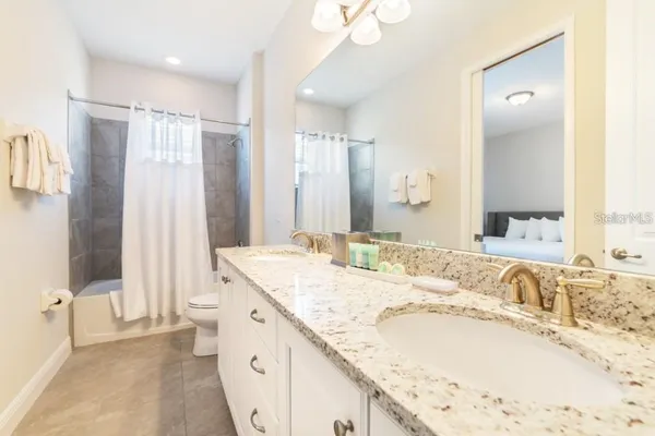 a spacious bathroom with a granite countertop sink and a mirror a bathtub