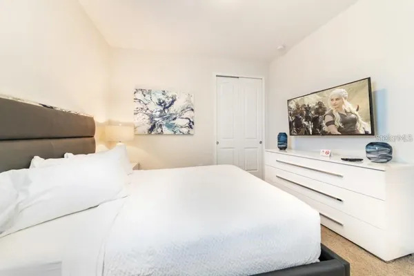 a bedroom with a bed and a flat screen tv