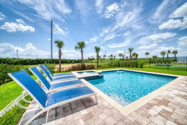 a view of a swimming pool with a patio and a yard