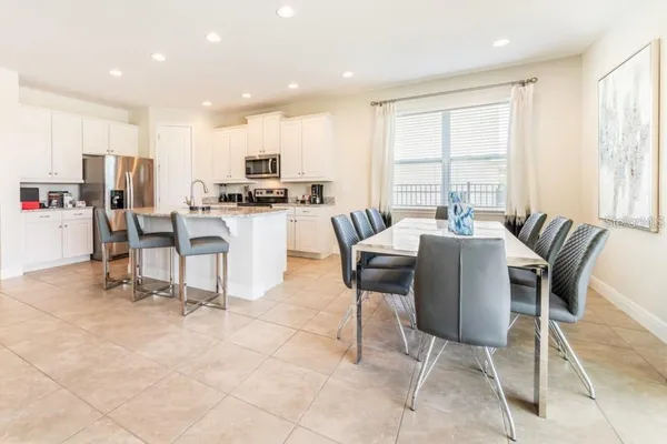 a kitchen with a dining table chairs and white cabinets