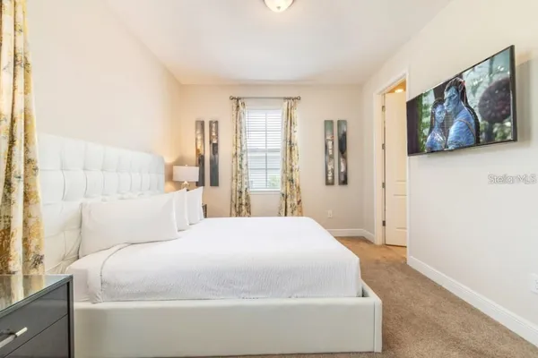 a spacious bedroom with a bed and a painting on the wall