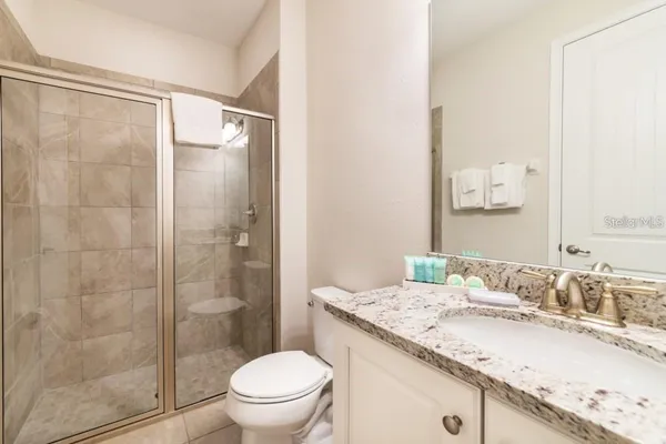a bathroom with a granite countertop sink toilet and shower