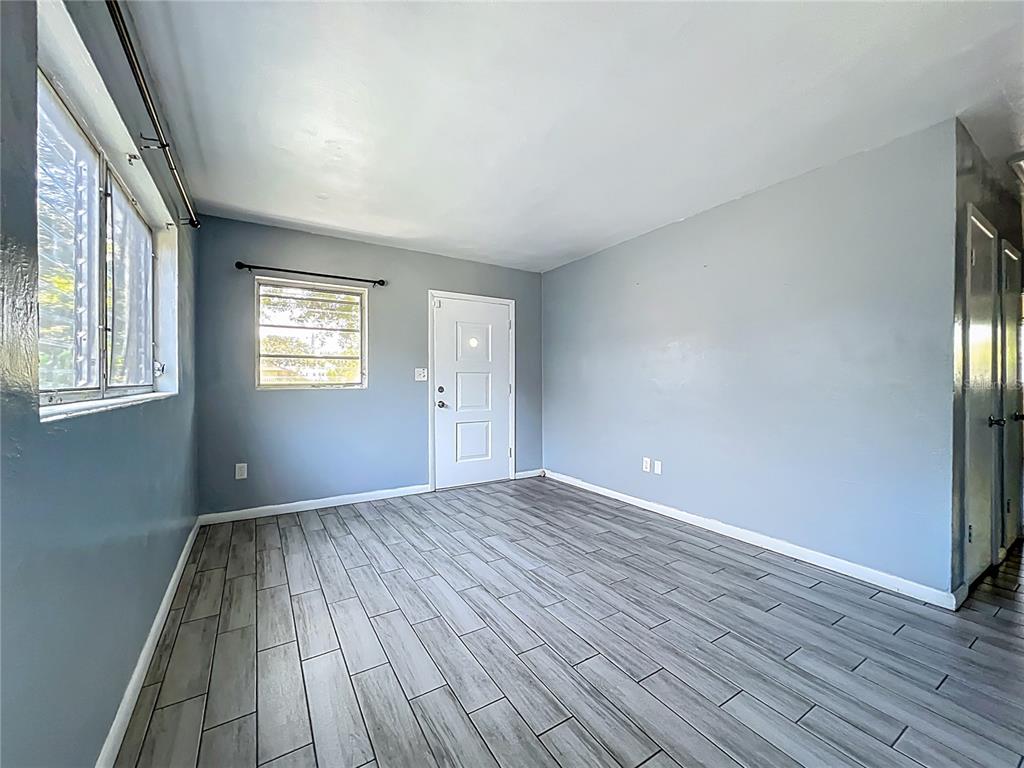 1025 South Central Avenue Lakeland, FL 33815 - Photo 14 of 42 a view of an empty room with wooden floor and a window