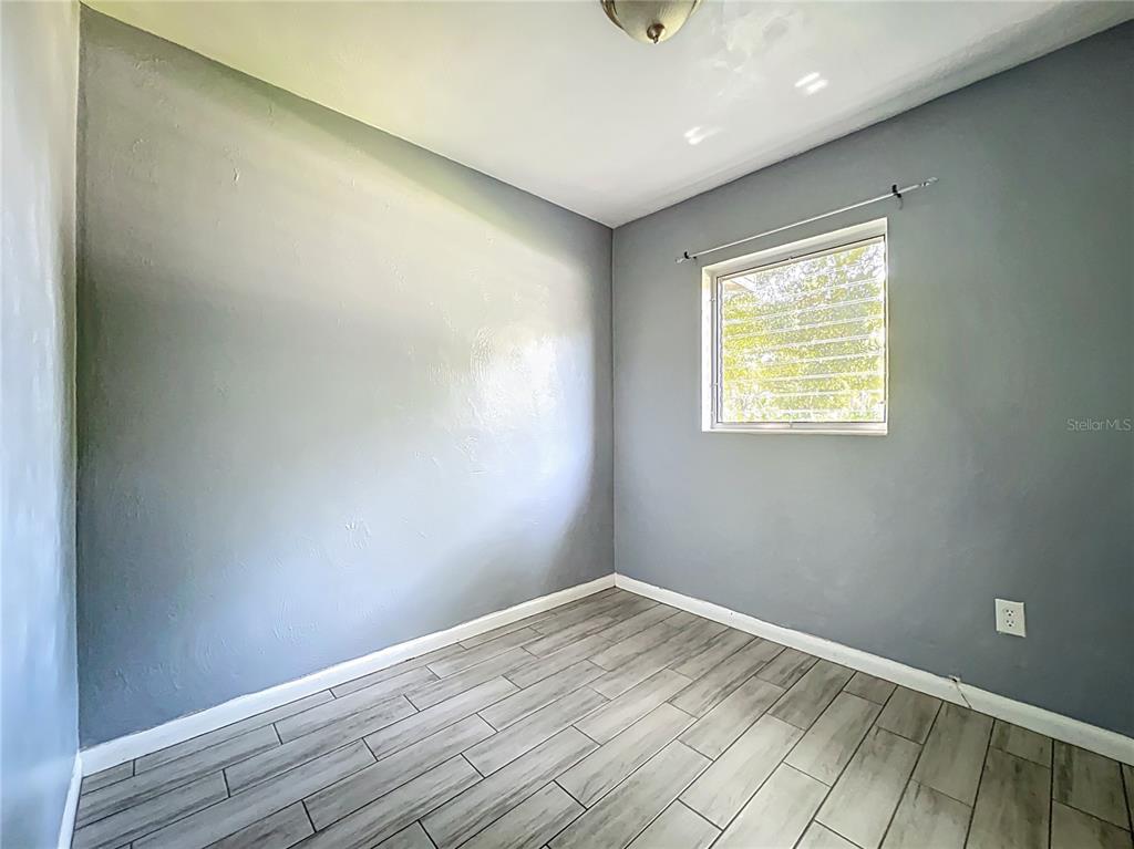 1025 South Central Avenue Lakeland, FL 33815 - Photo 17 of 42 an empty room with wooden floor and a window