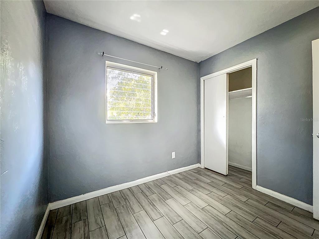 1025 South Central Avenue Lakeland, FL 33815 - Photo 18 of 42 an empty room with wooden floor and windows