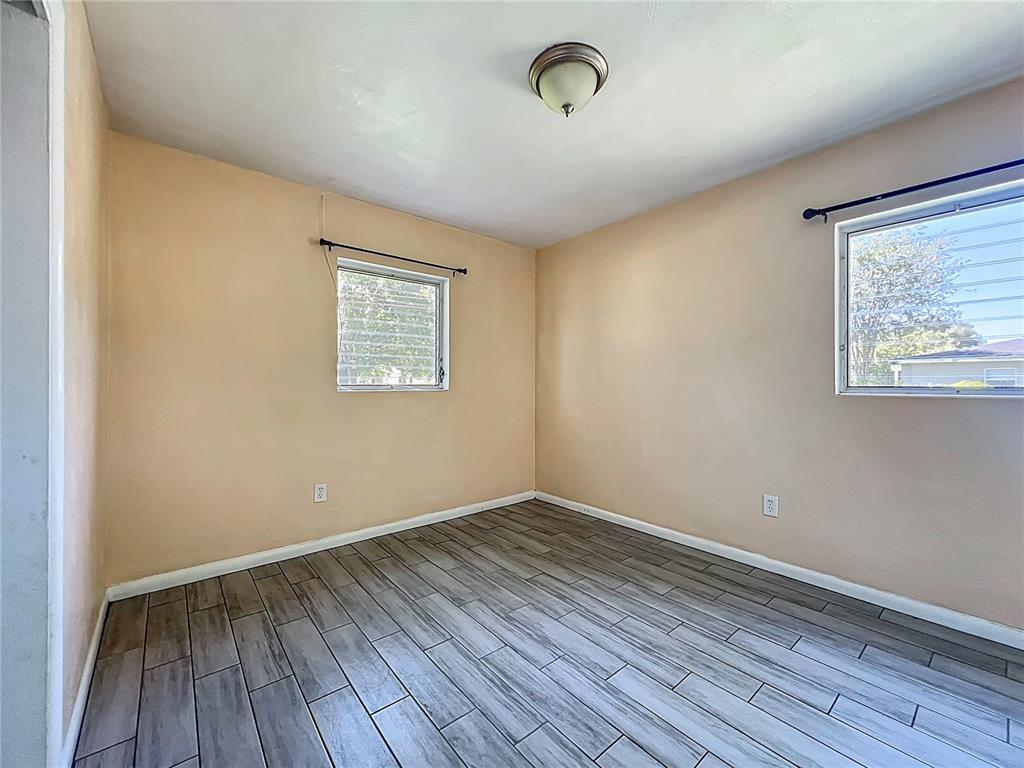1025 South Central Avenue Lakeland, FL 33815 - Photo 20 of 42 an empty room with wooden floor and windows