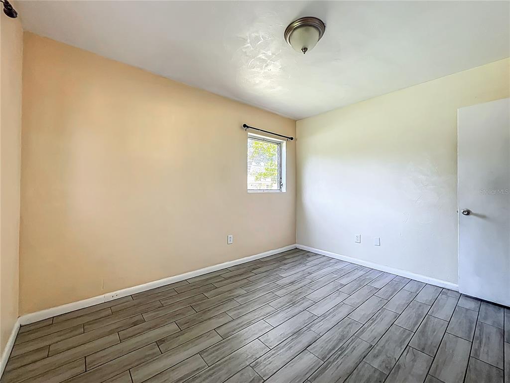 1025 South Central Avenue Lakeland, FL 33815 - Photo 21 of 42 an empty room with wooden floor and windows