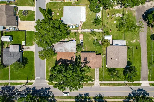 an aerial view of a house with a yard and table chairs and fire pit
