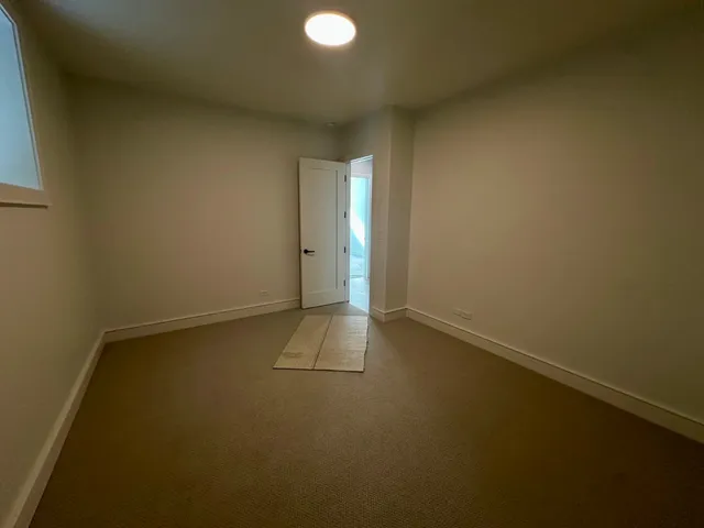 a view of an empty room with closet and a window