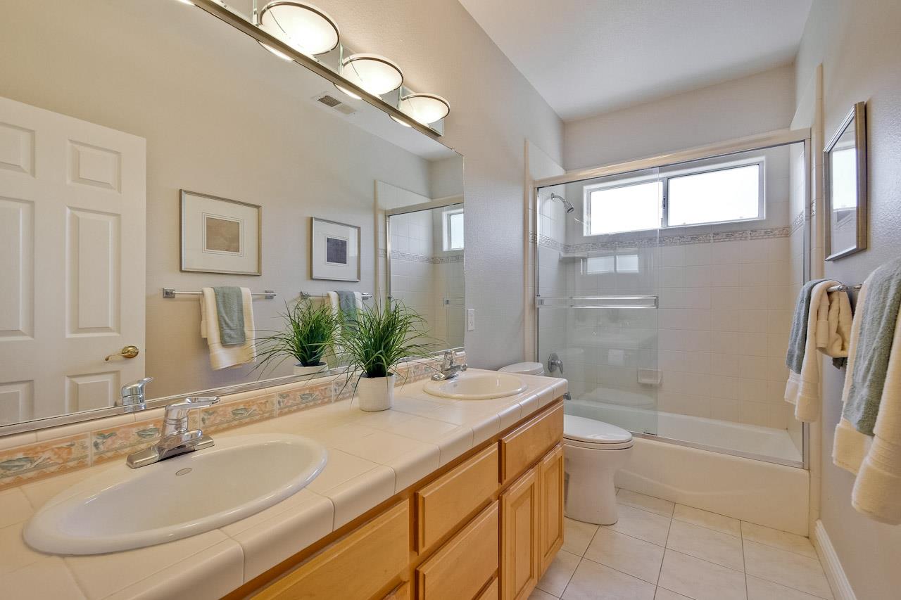 7648 Echo Hill Court Cupertino, CA 95014 - Photo 45 of 50 a bathroom with a granite countertop sink and a mirror a bathtub