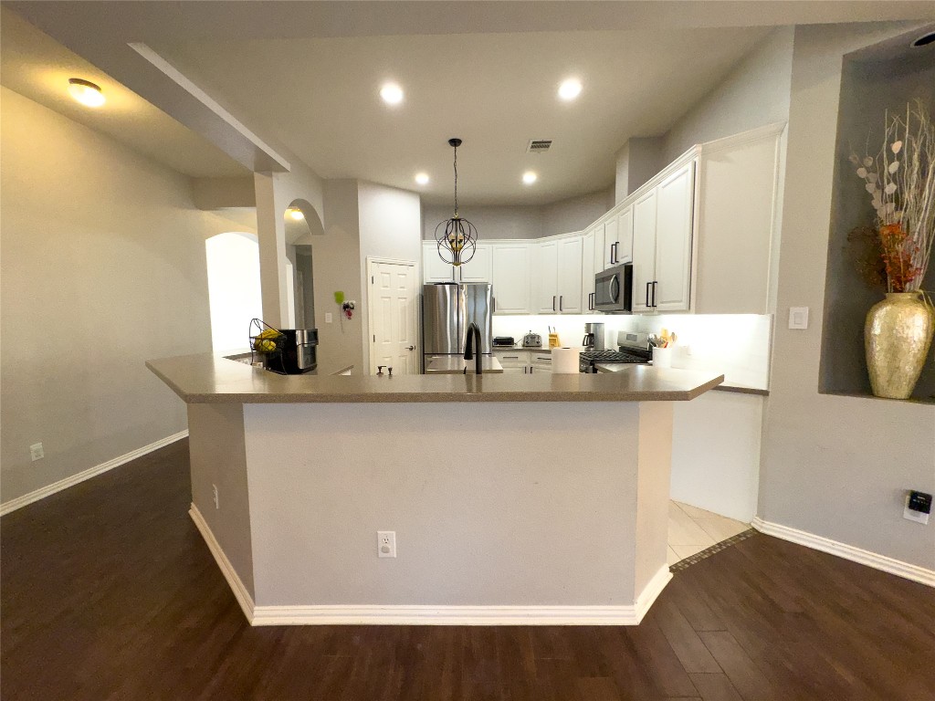 2410 Aspen Meadow Road Leander, TX 78641 - Photo 7 of 24 a view of counter top space with stainless steel appliances furniture refrigerator and wooden floor