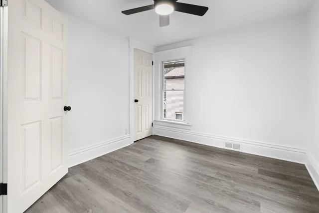 a view of an empty room with wooden floor