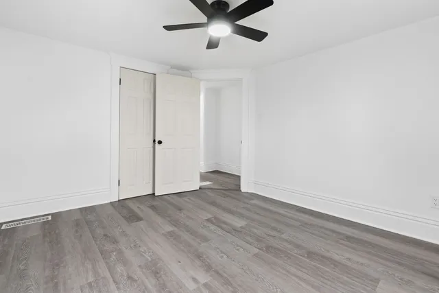 a view of an empty room with wooden floor