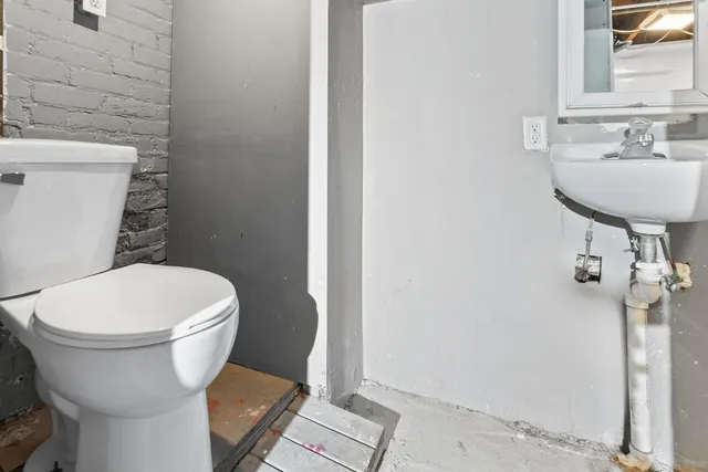 a white toilet sitting next to a bathroom sink