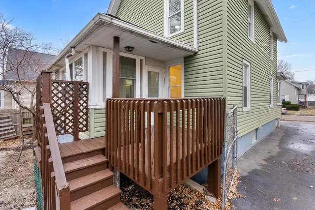 a backyard of a house with large trees and outdoor seating