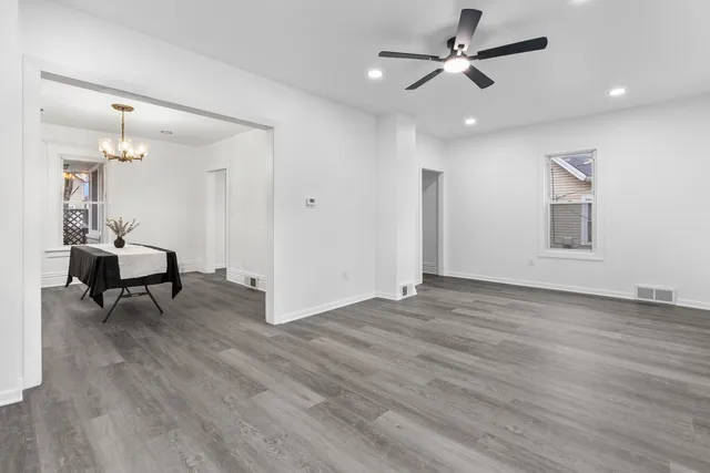 a view of an empty room with a window and wooden floor