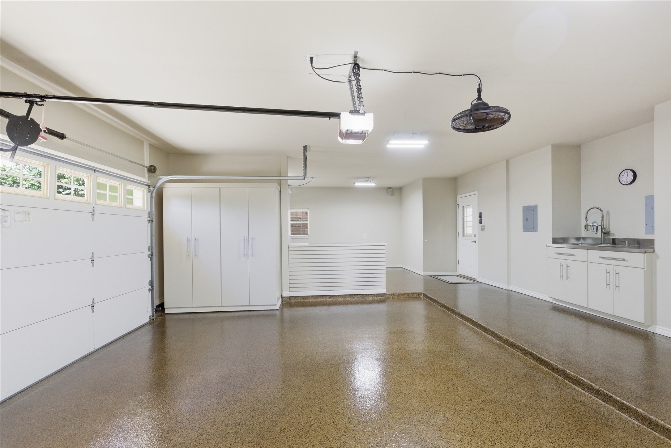1204 Orlando Road Austin, TX 78733 - Photo 12 of 40 A well-appointed garage boasts ample storage, a utility sink, and a gleaming epoxy floor.