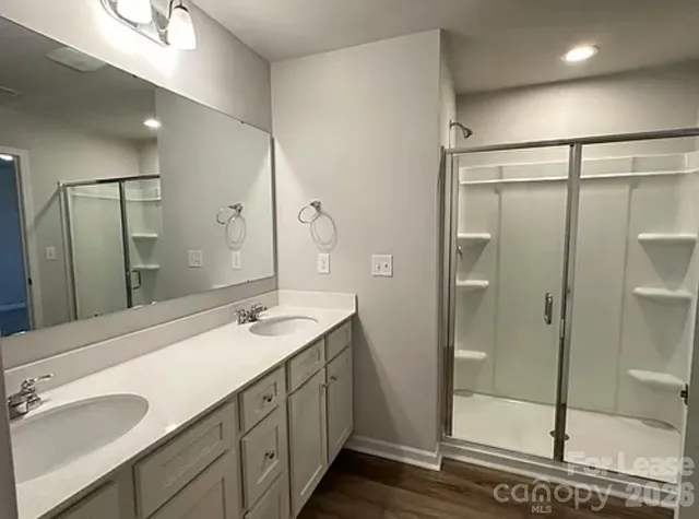 a bathroom with a granite countertop sink mirror and shower