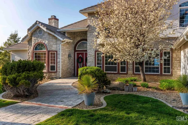 a front view of a house with garden and outdoor seating